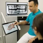 Tandarts laat een patiënt op het scherm de röntgenfoto en digitale scan van het gebit zien